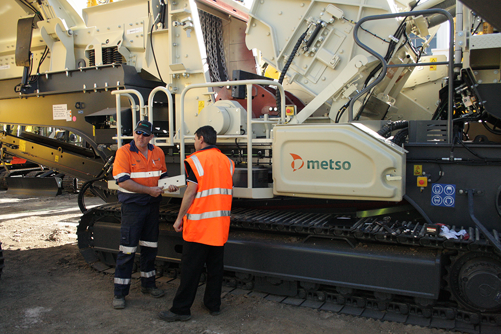 Two employees in front of Metso Outotec's Lokotrack