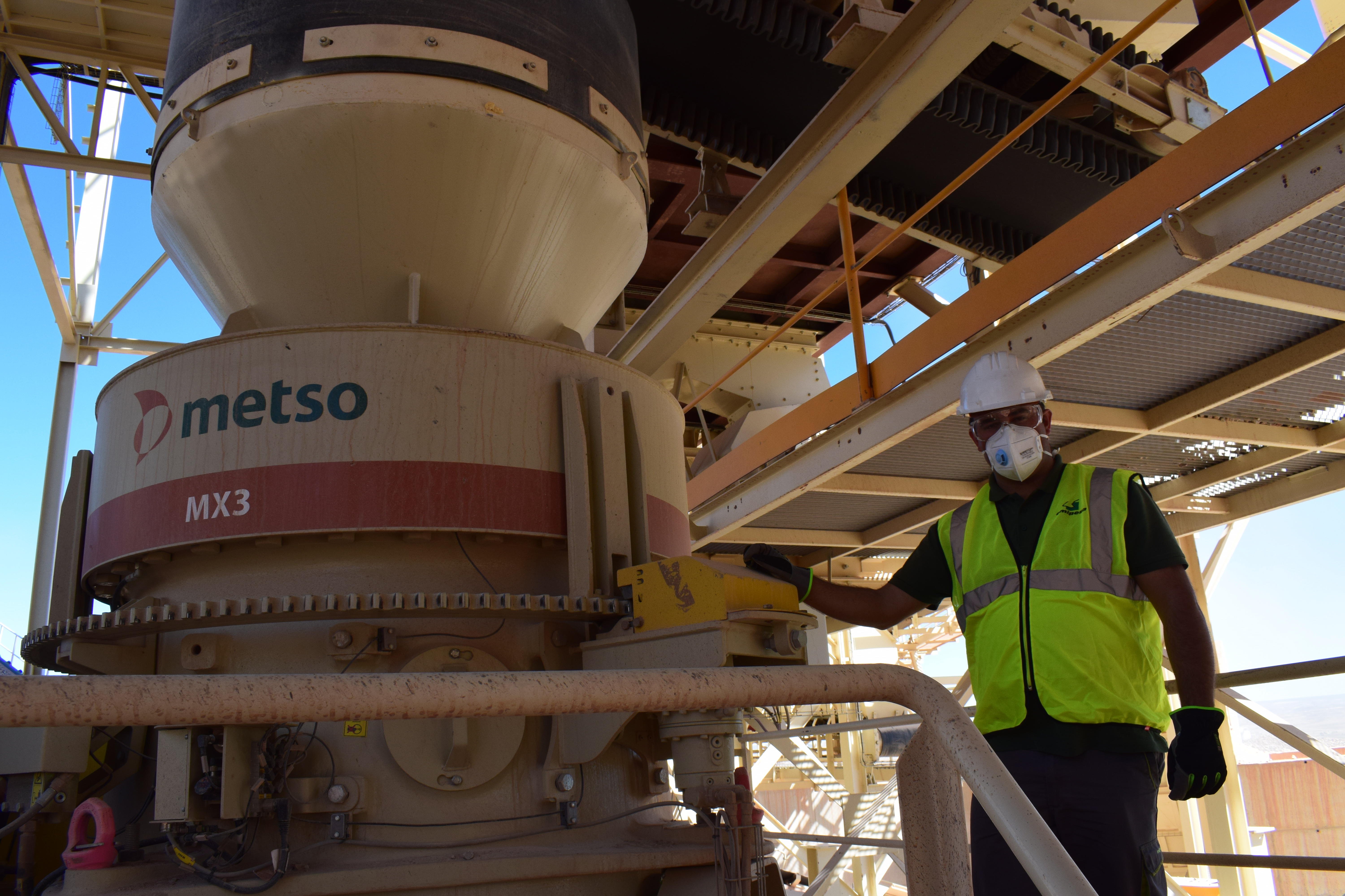 MX3 cone crusher and a man standing next to it at Emipesa site.