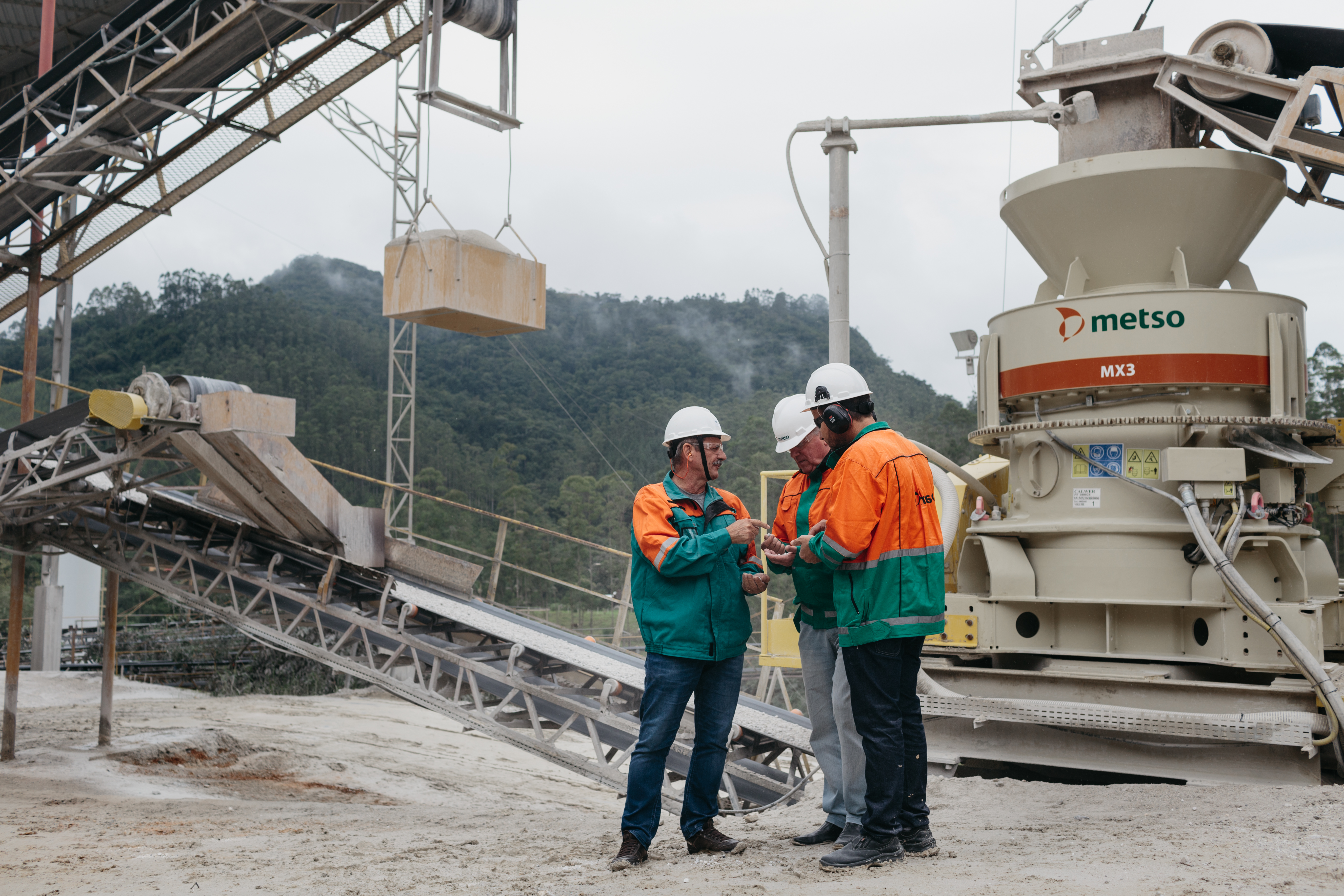 Three Metso employees in front of MX3 crusher at Calwer Quarry