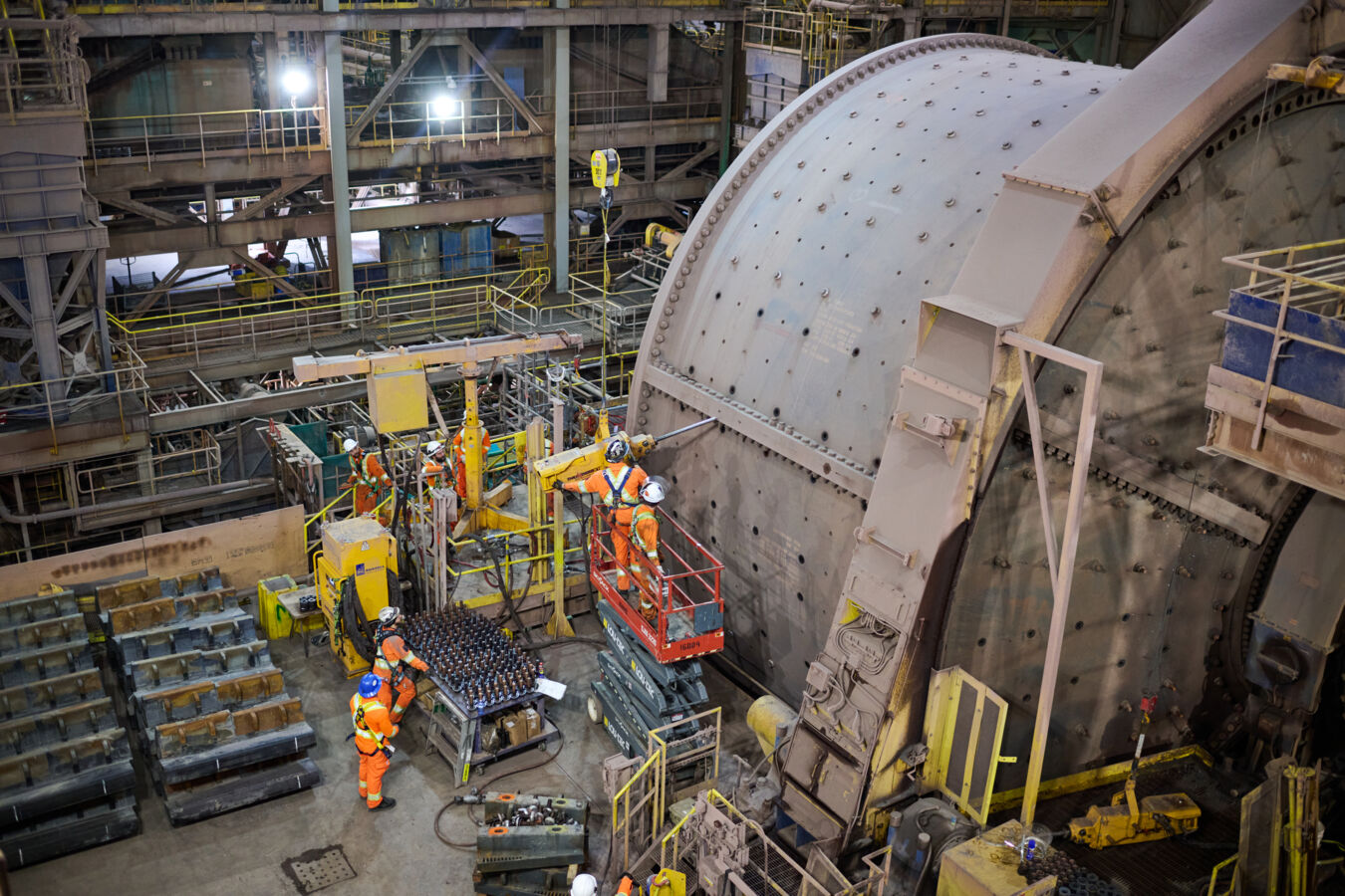 Metso reline team in safety gear removing bolts off a grinding mill and stagging mill linings for a relining event at Bloom Lake Mine in Quebec