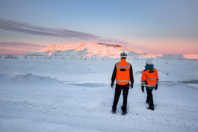 Two Metso Outotec employees in a wintery mine scene.